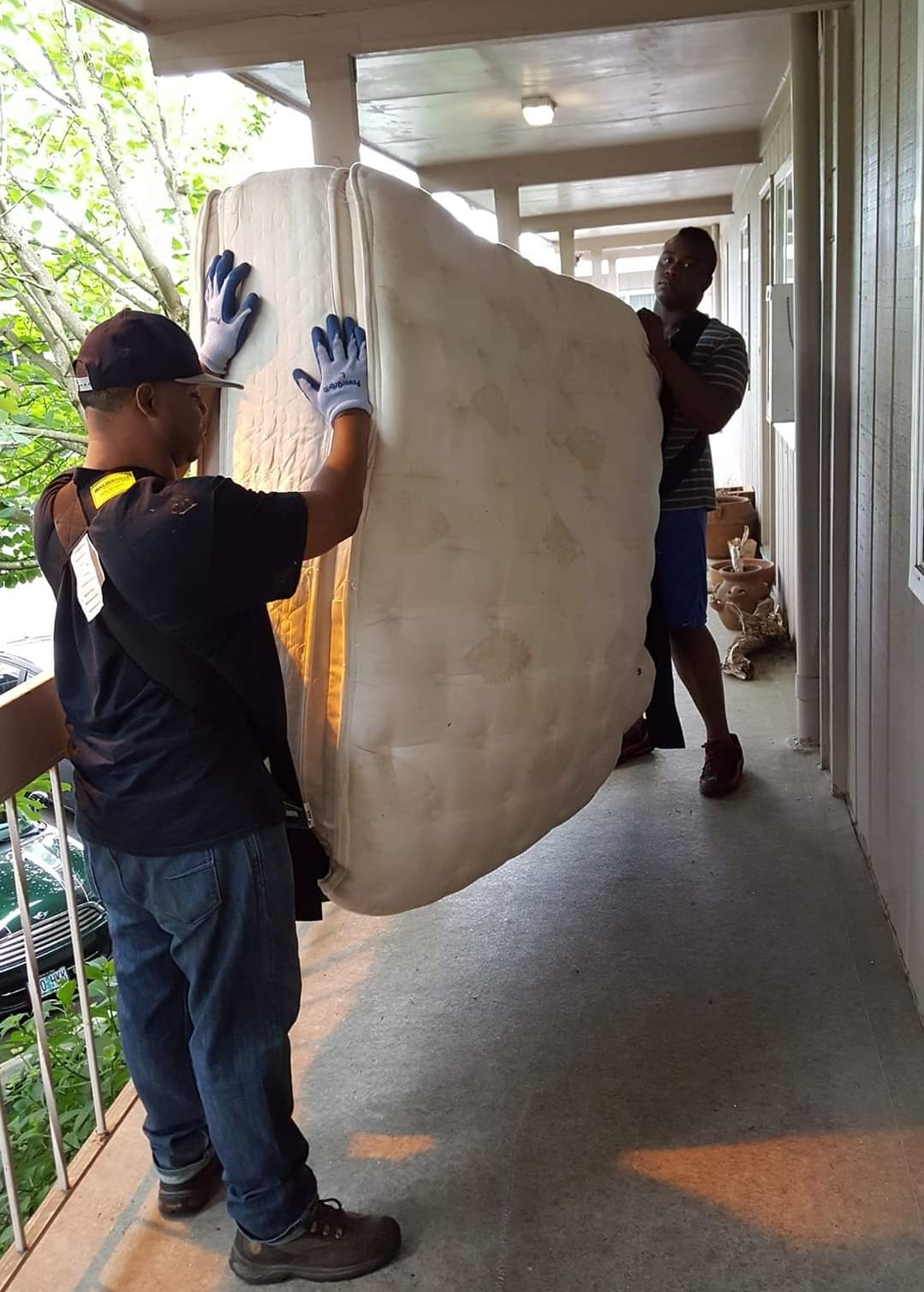 Junk removal technicians removing a King size mattress - 503 Clutter Busters