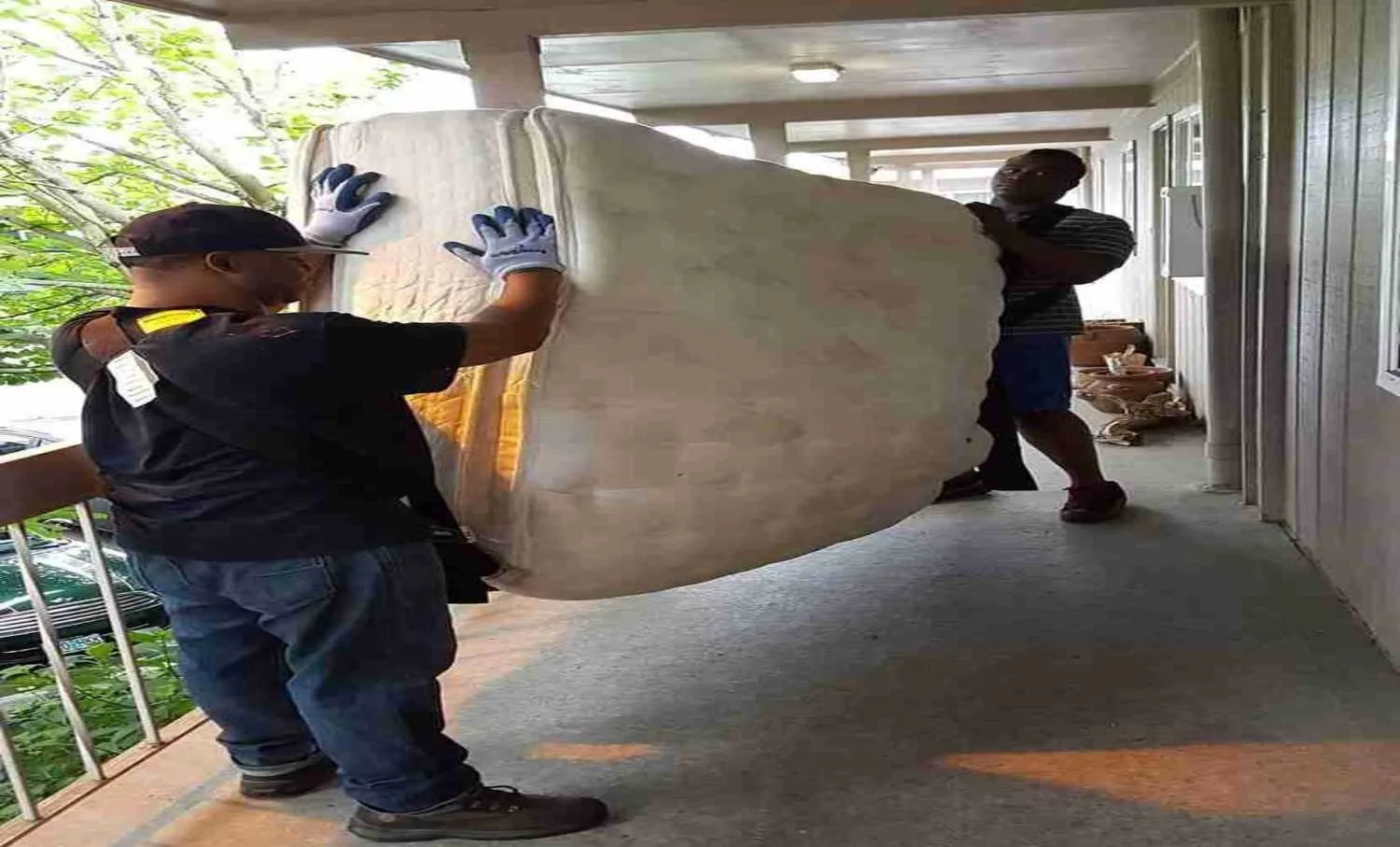 Two-person 503 Clutter Busters crew carrying an old mattress out of a Portland home for same-day removal