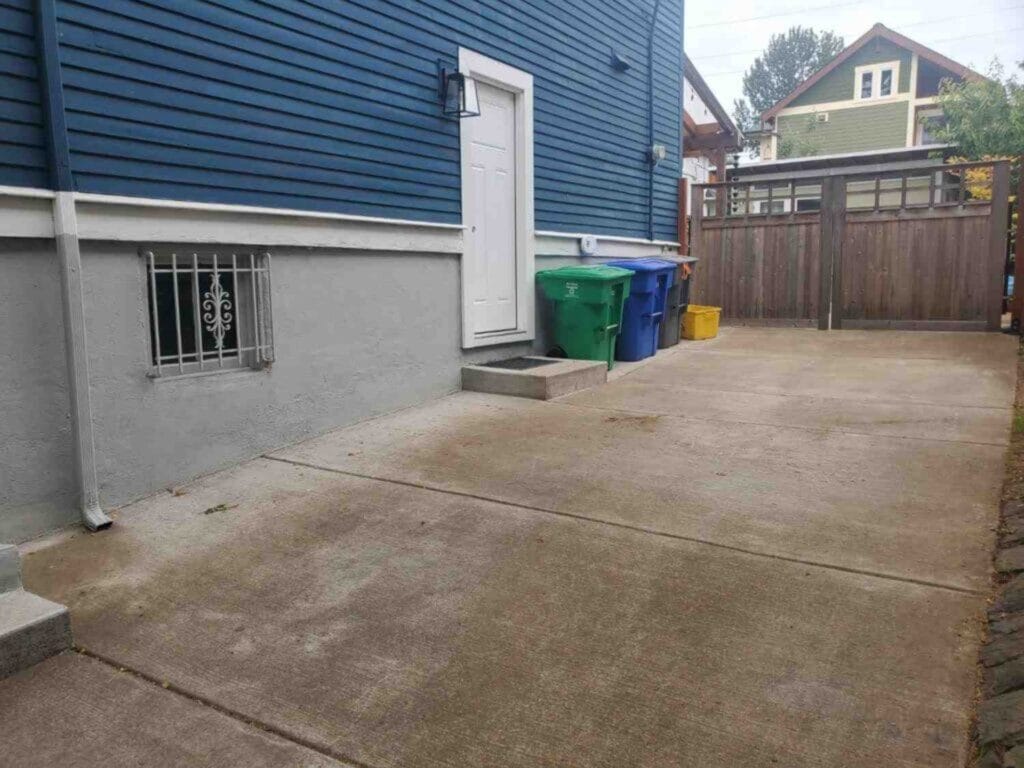 Clean, completely cleared concrete driveway and side entrance of a Portland home after local junk haulers cleared all debris.