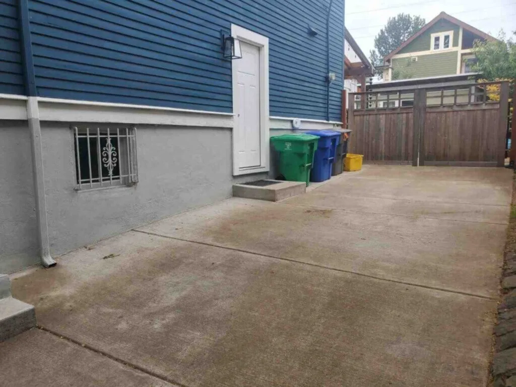 Clean, completely cleared concrete driveway and side entrance of a Portland home after local junk haulers cleared all debris.